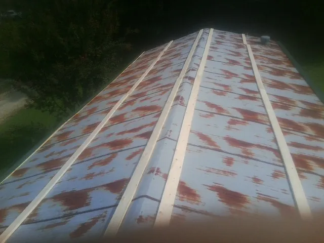 Rusted metal roof panels with new wood purlins before replacement — Storm Damage Roof Repair in Sully by Roofing Brothers
