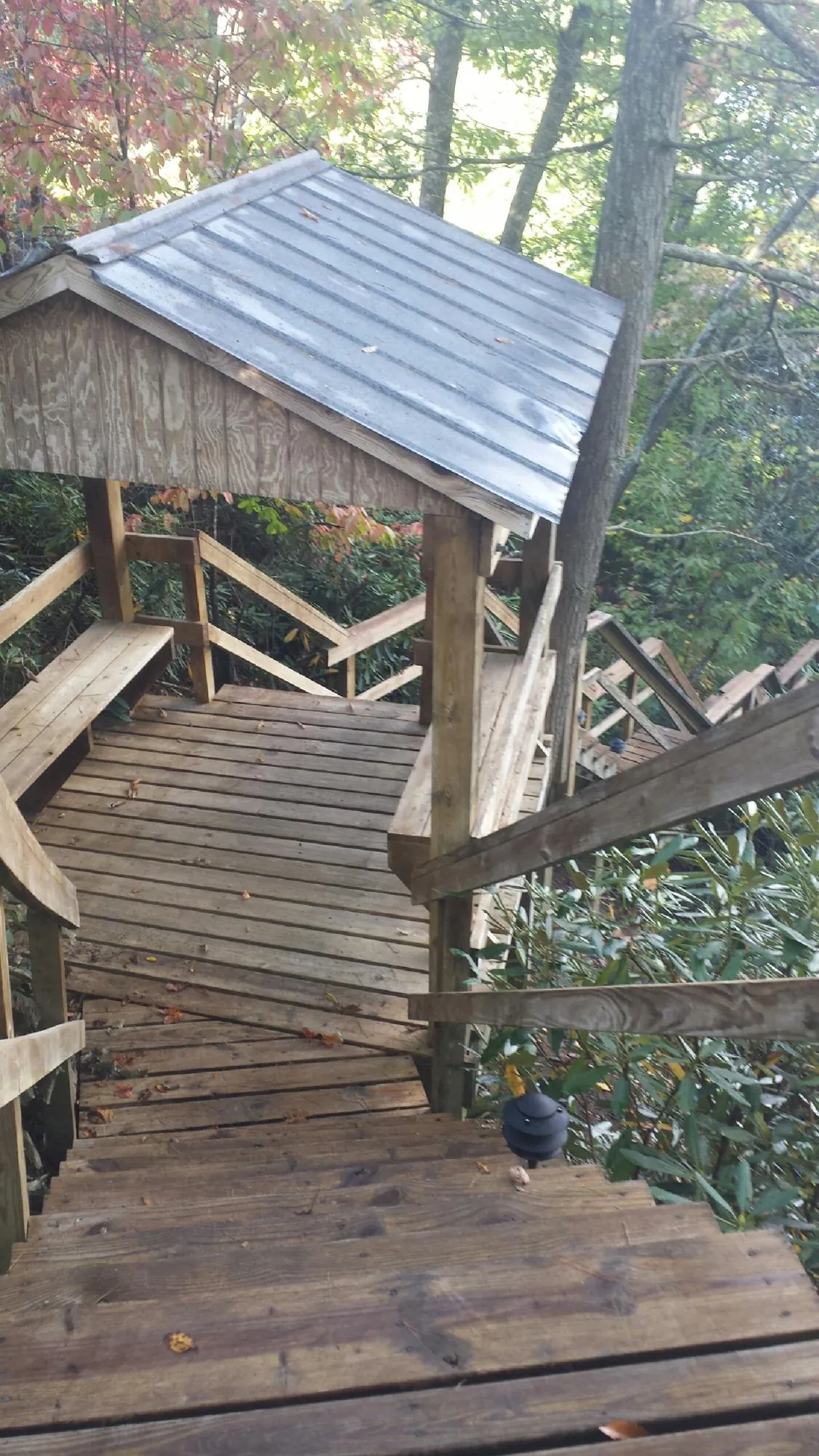 Metal roofed shelter over wooden steps on a wooded walkway — Skylight Repair & Installation work by our crew in Sully