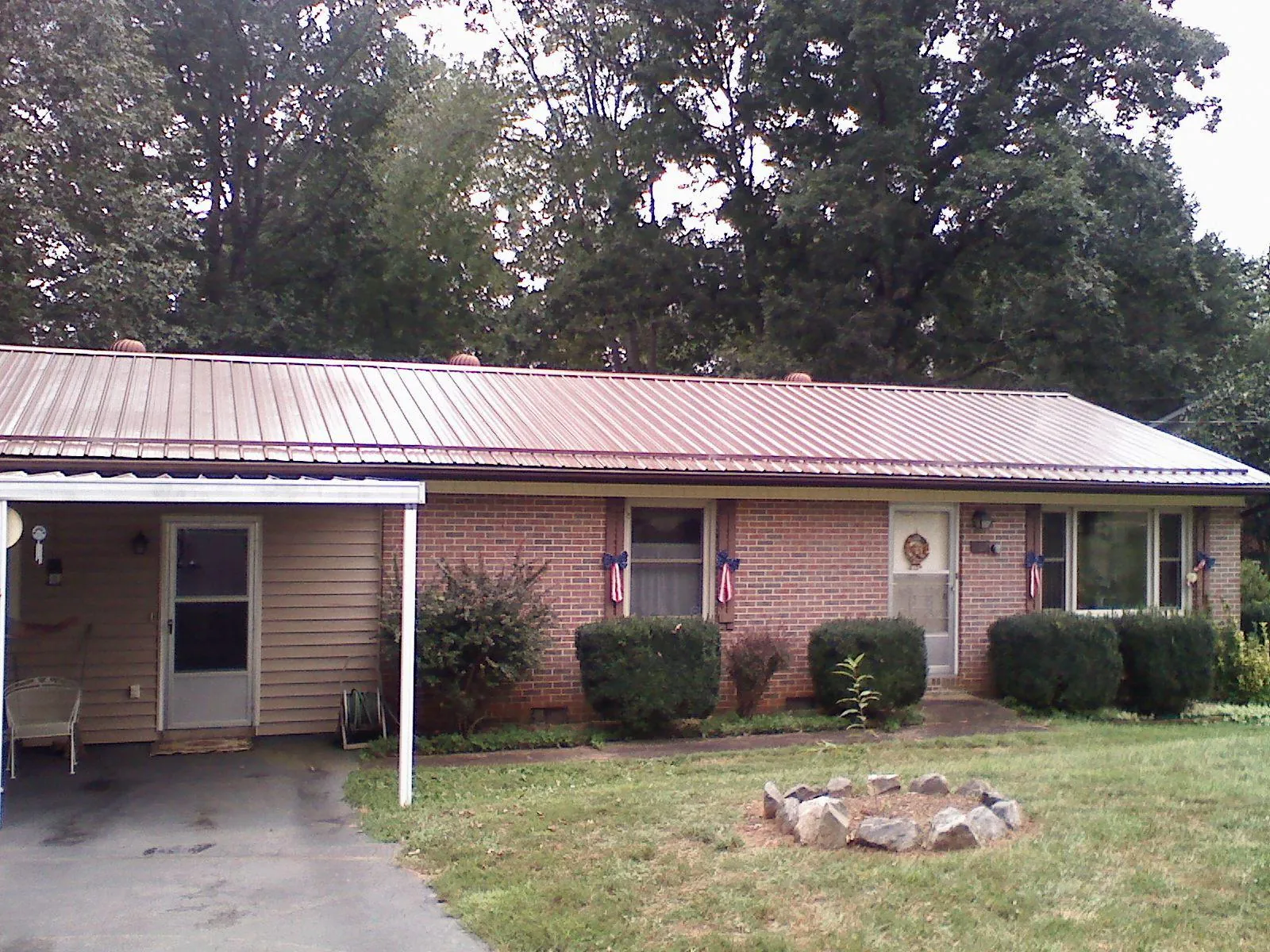 Bronze metal roof and carport on a brick ranch home — Roof Repair work by our crew in Sully